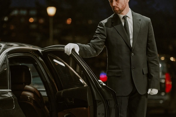 Professional chauffeur opening luxury car door, representing Chauffeur Service Sydney.